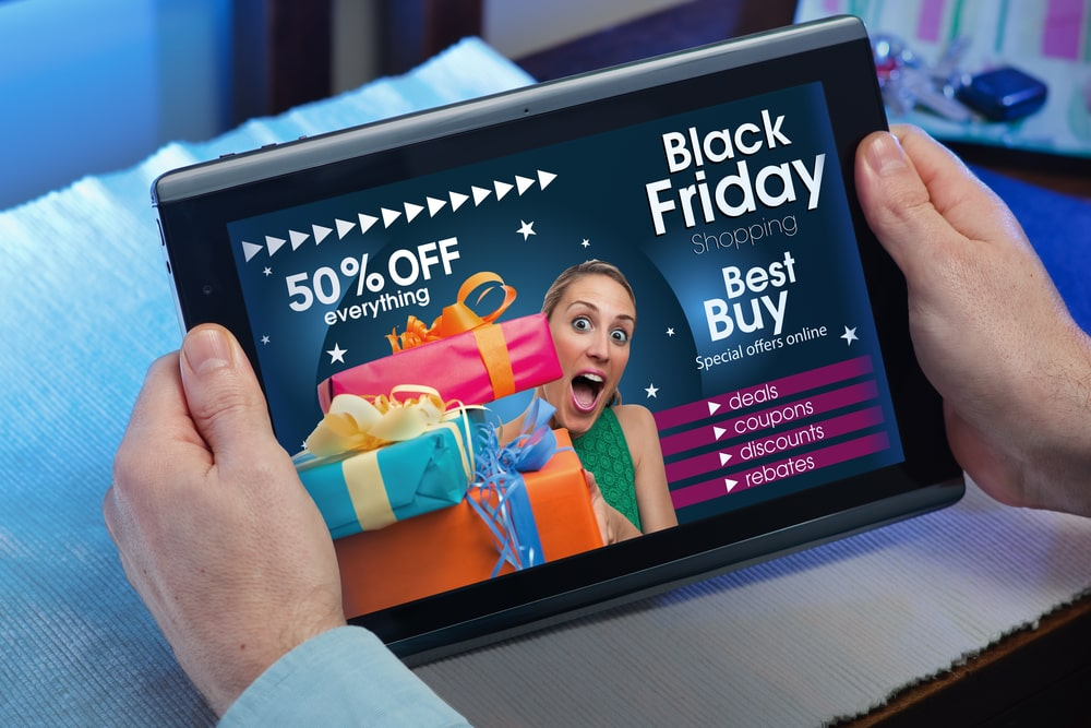 une personne tenant une tablette avec une offre du Black Friday sur l'écran