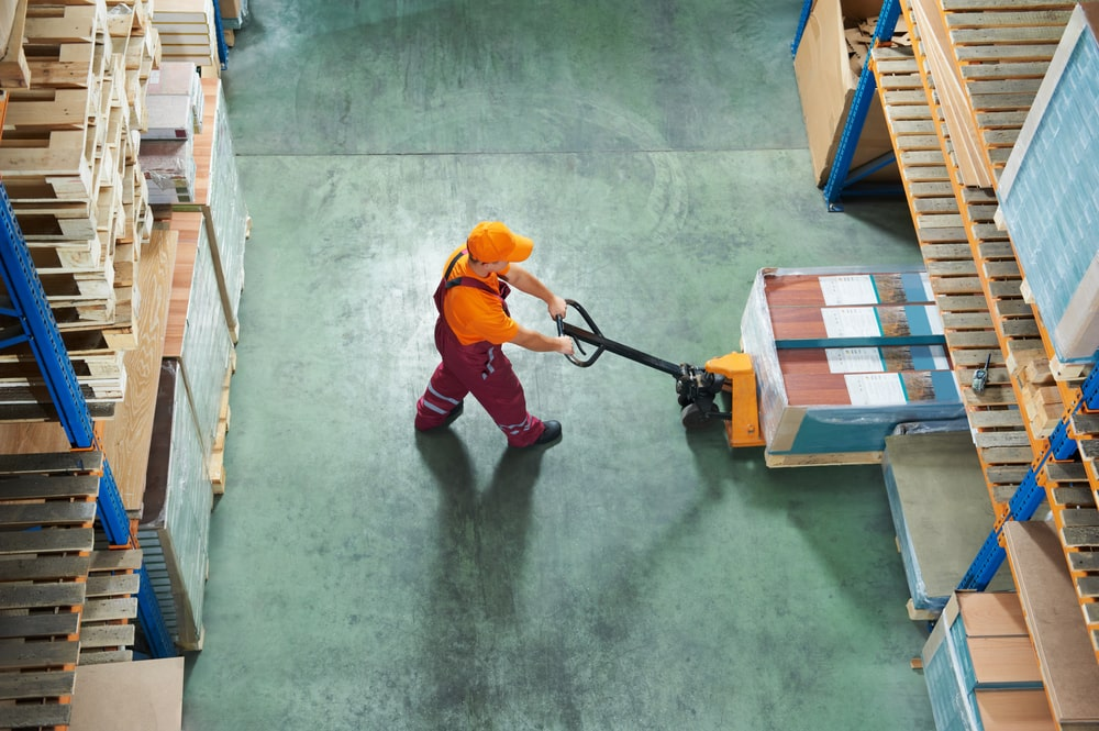 a person in a warehouse with a pallet truck