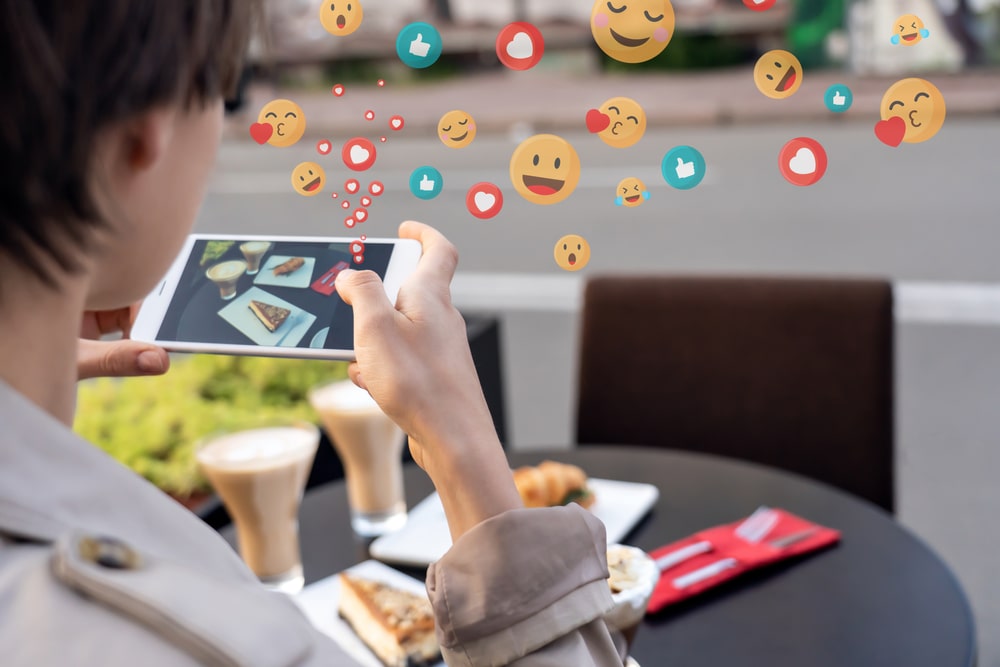 une personne prenant une photo de nourriture avec de multiples emojis