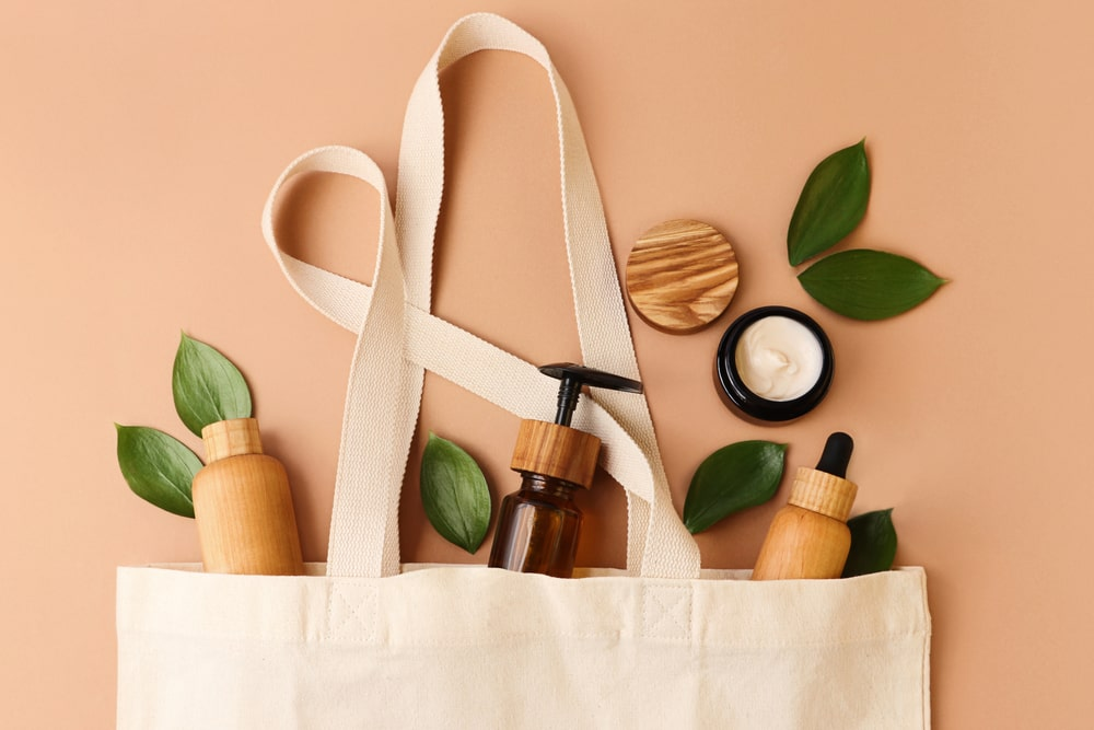 a canvas bag with reusable bottles and leaves