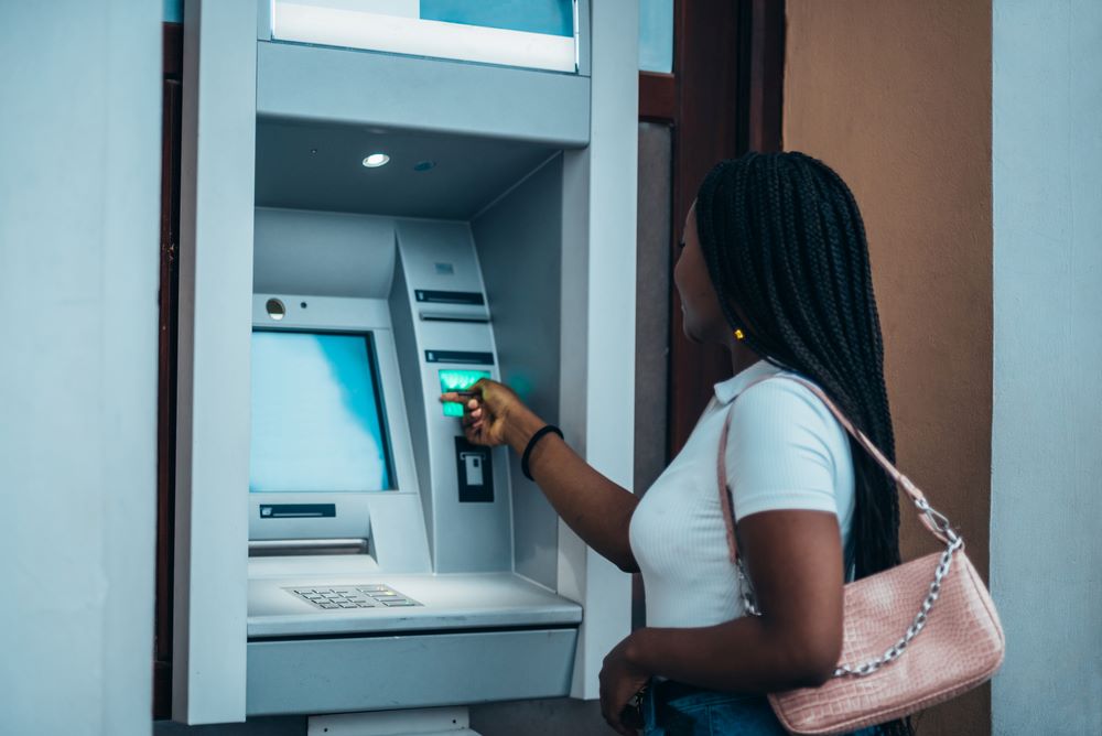 A woman withdrawing cash at an ATM.