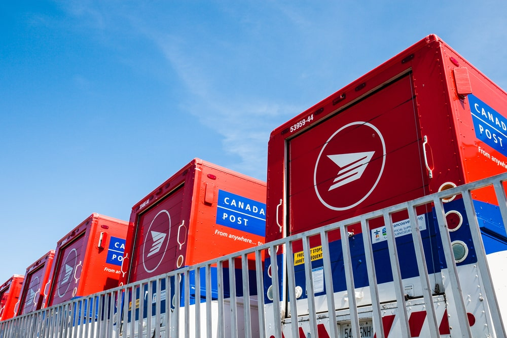 a row of Canada Post trucks with white railings