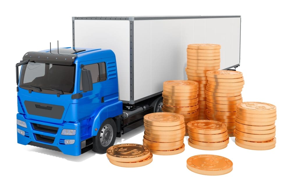 Stack of coins outside a miniature delivery truck